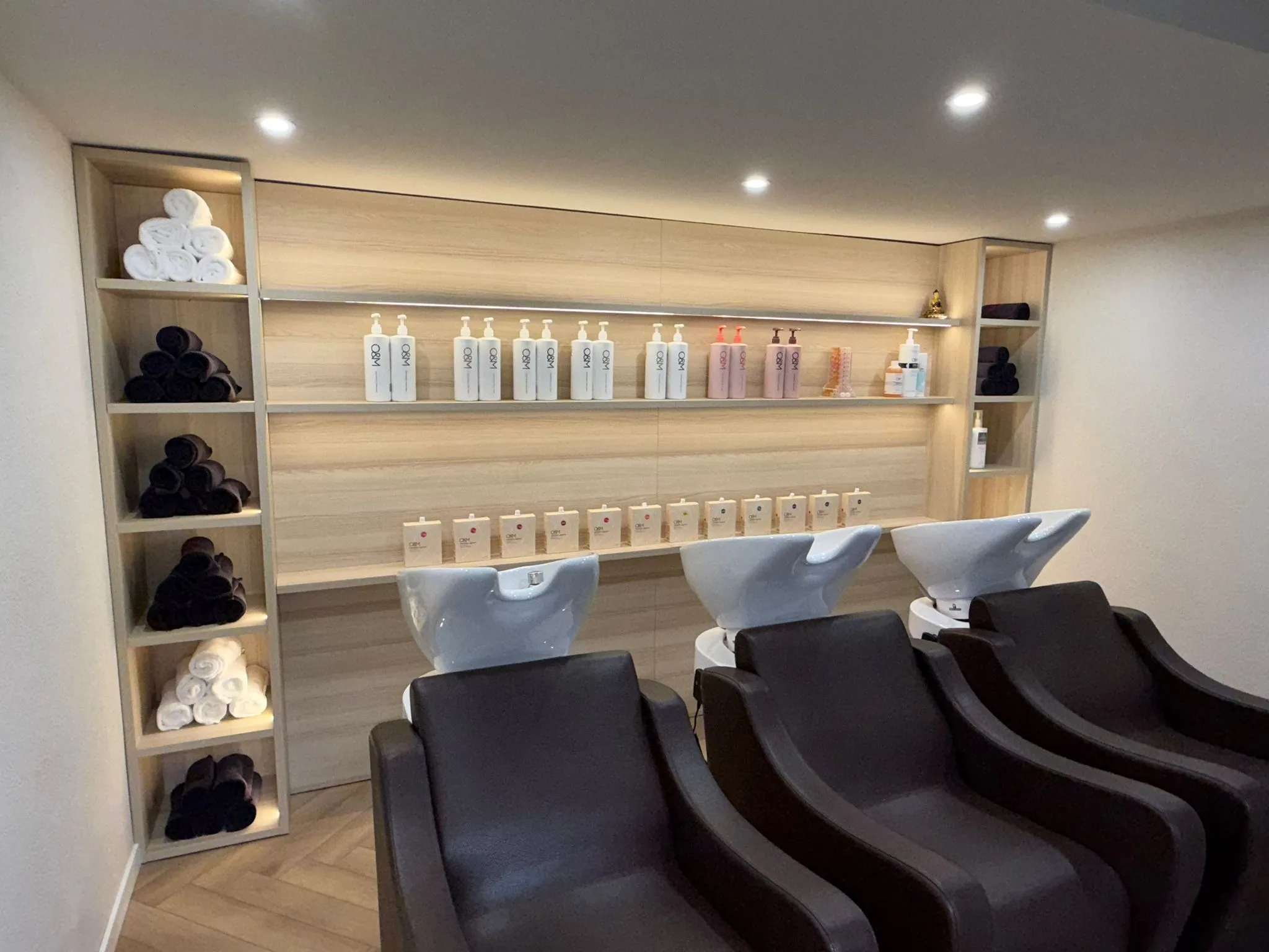 Elegant styling stations with warm wood tones and deep green walls.