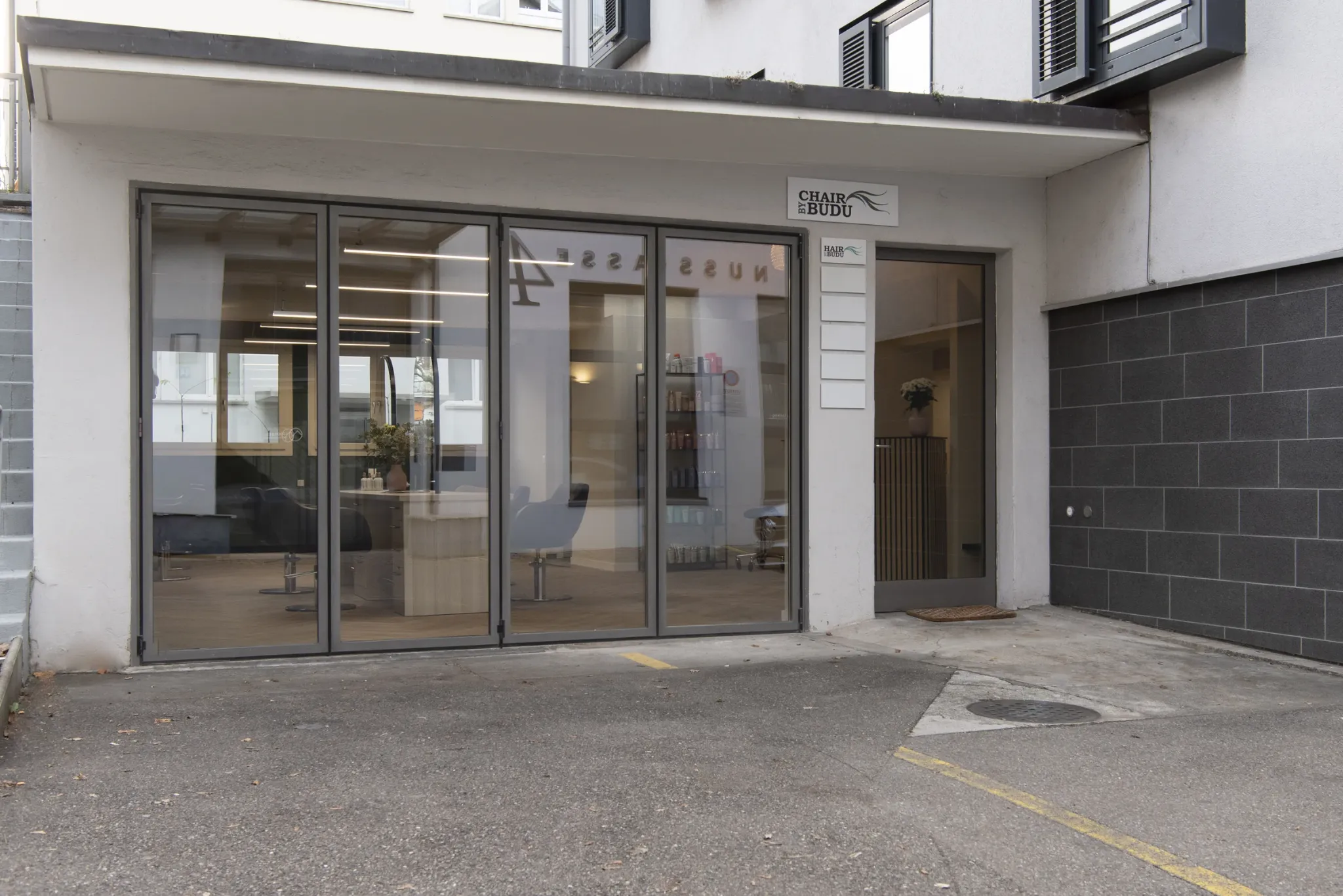 Exterior view of the salon entrance with direct access and parking nearby.